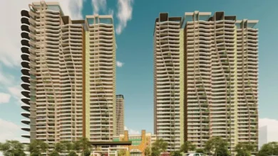 NBCC sells 111 residential flats in Noida through an e-auction, featuring apartment buildings and a residential property development.